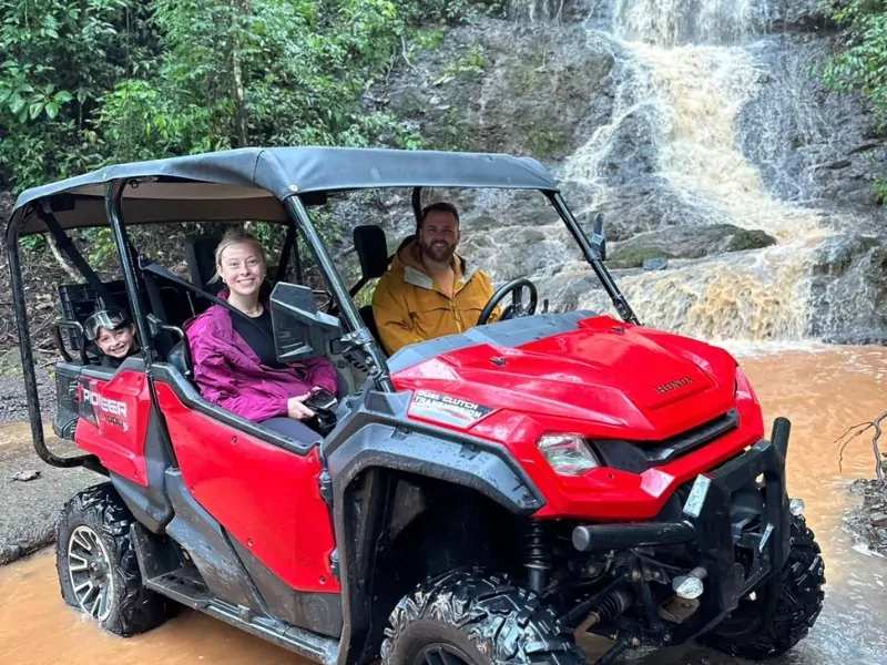 A family on a red ATV rental at the Jaguar waterfalls in Jaco Costa Rica